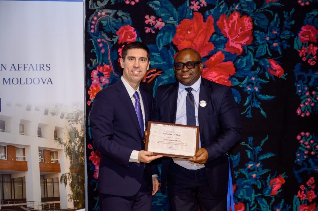 Deux représentants présentent le Diplôme de Mérite remis au Consul honoraire.